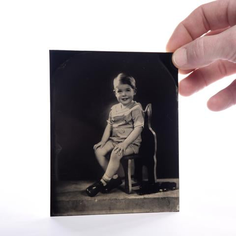 digital tintype picture of a boy seitting on a chair